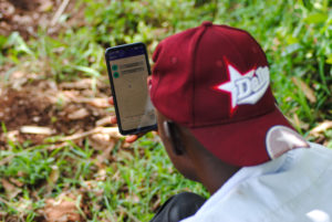 Man wearing red cap looking at smartphone