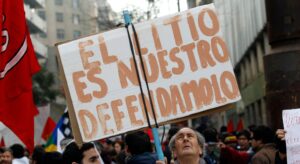 man holds up a sign calling for the defence of lithium at a protest