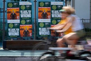 a person riding a bicycle
passing by a wall of posters