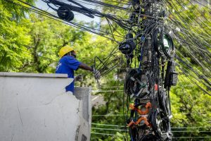 Un hombre con equipo de seguridad trabaja en un poste eléctrico.